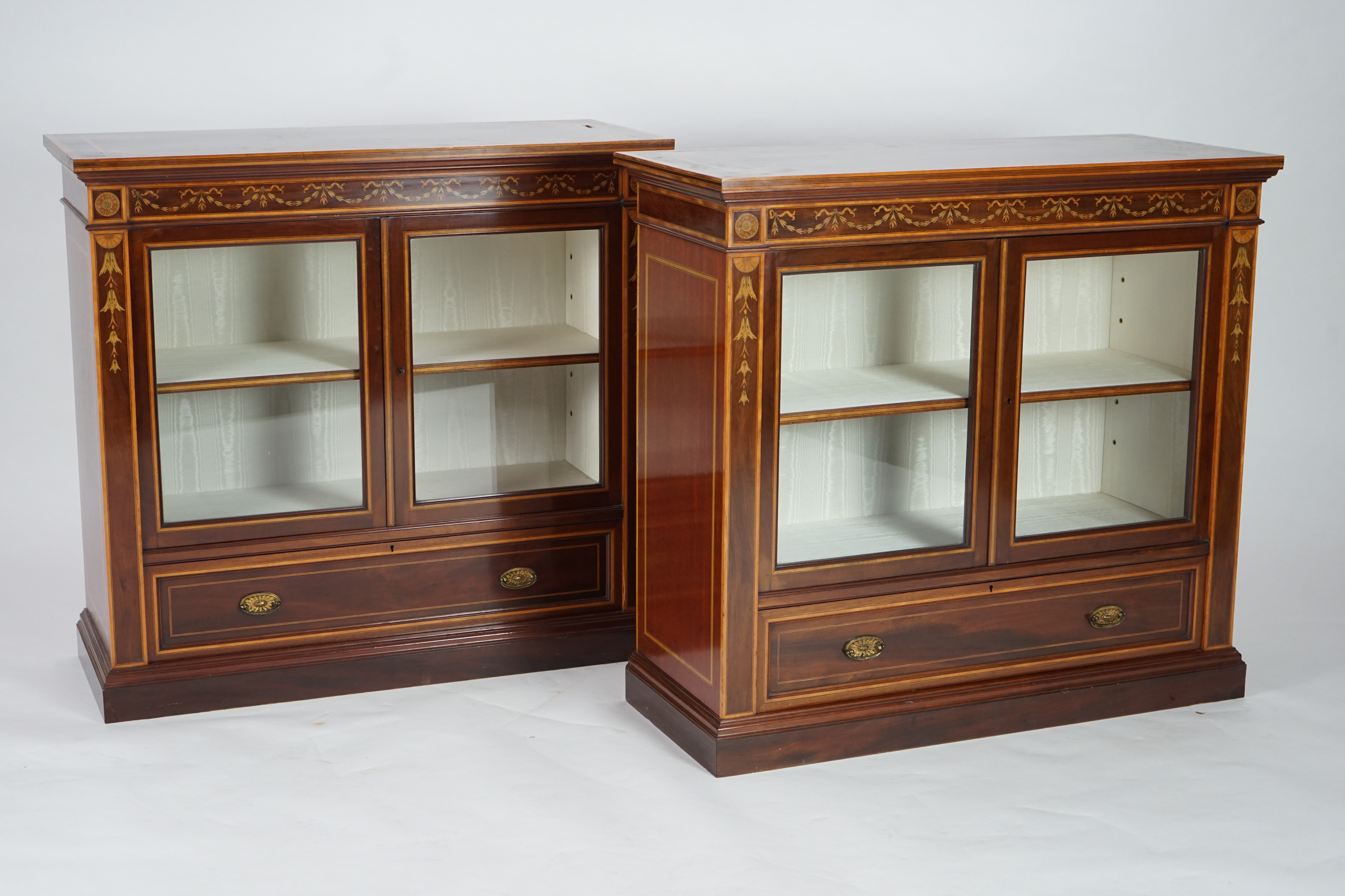 A pair of Edwardian marquetry inlaid and satinwood banded mahogany side cabinets, by Gillows